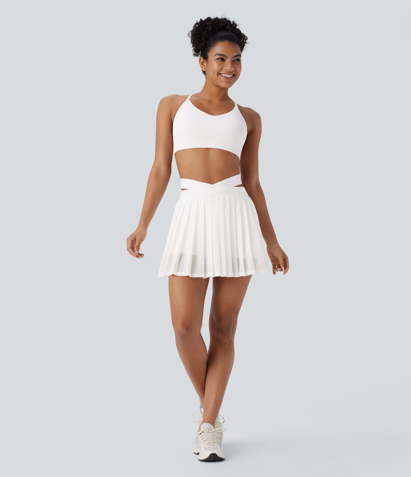 Jupe de yoga plissée 2-en-1 taille haute avec poches latérales, effet croisé et empiècements en mesh contrastés