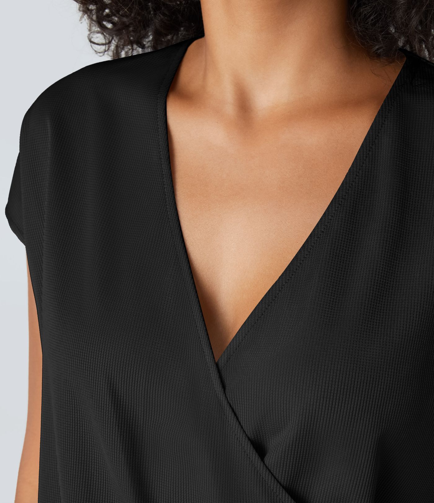 Kurzer Jumpsuit mit V-Ausschnitt, kurzen Ärmeln, plissierten Seitentaschen und fließendem Waffelmuster