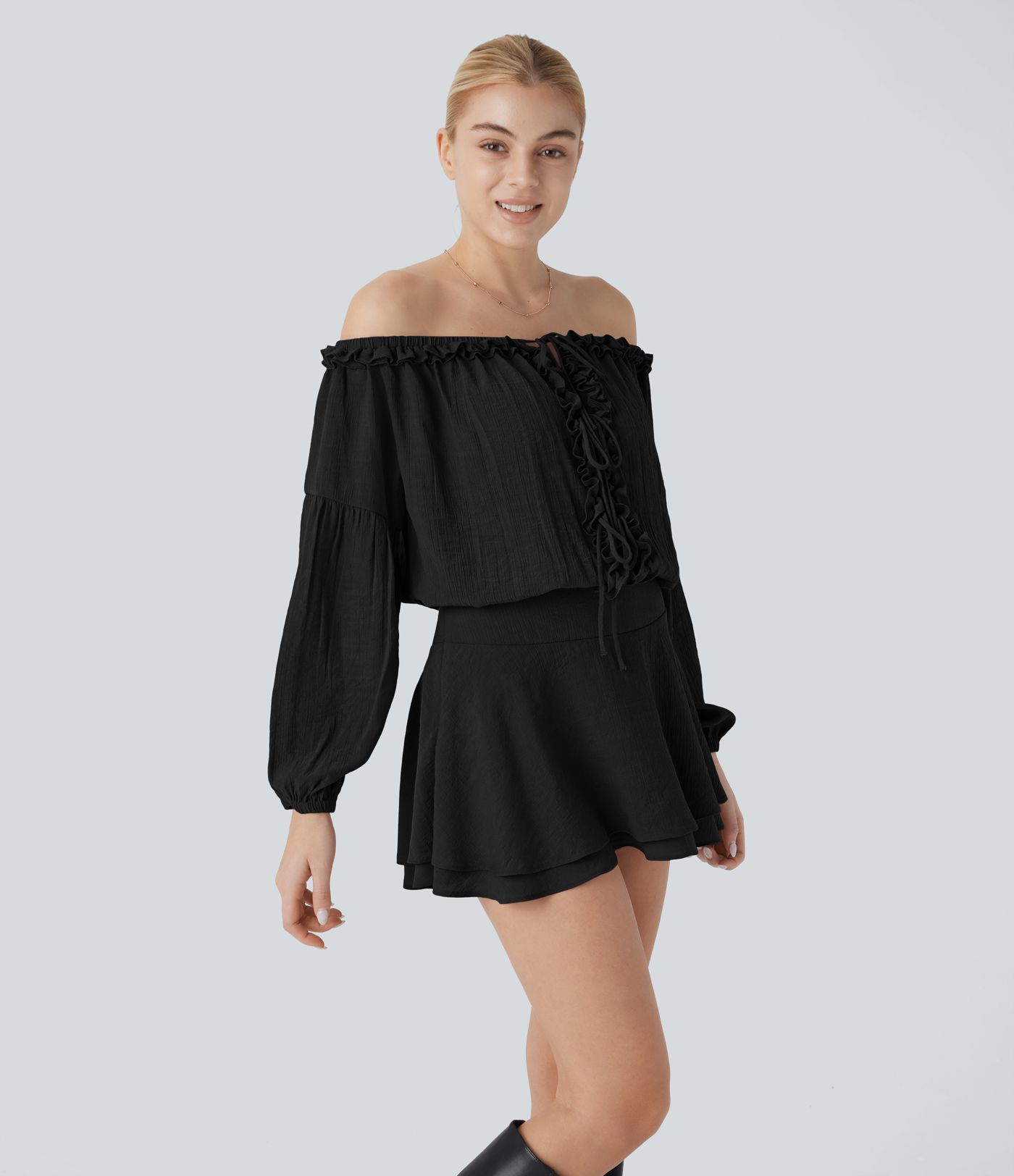 Mini-robe en dentelle à épaules dénudées, manches longues, avec détails en ruban et jupe à plusieurs couches.