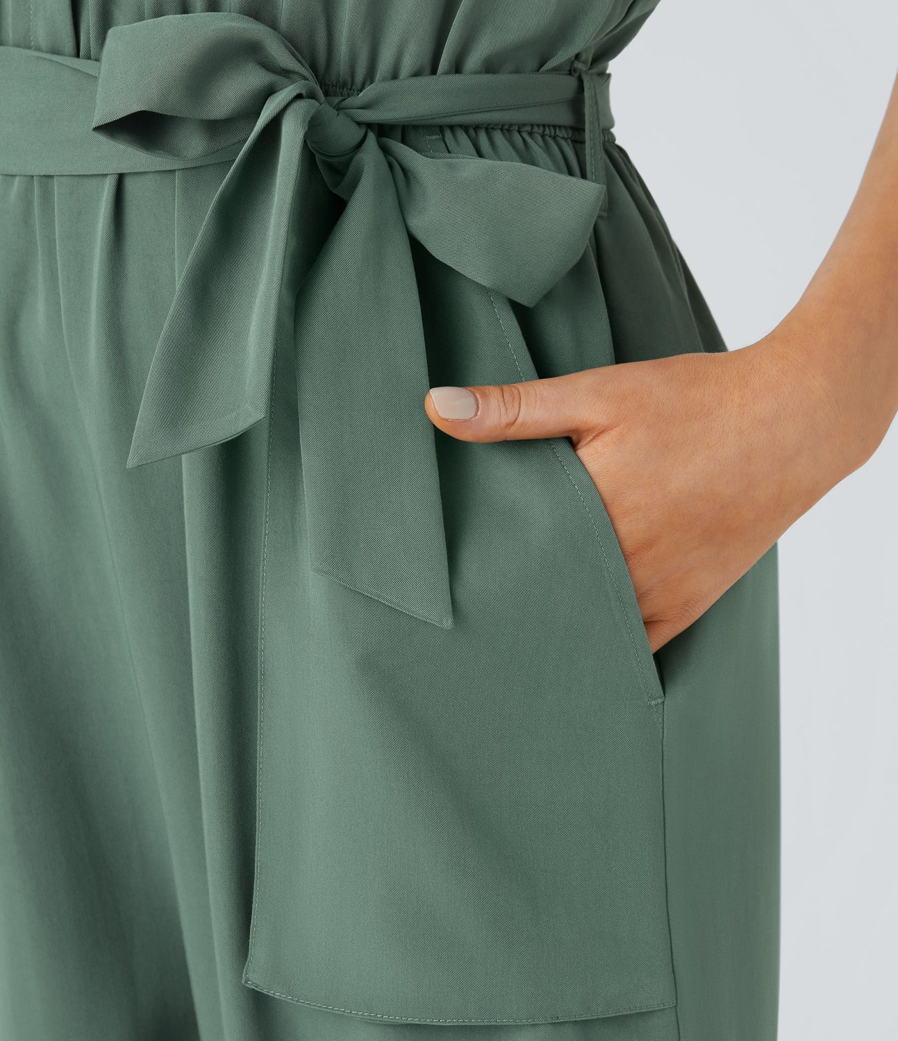 V-neck sleeveless zipper belted jumpsuit with side pocket details in a casual style.