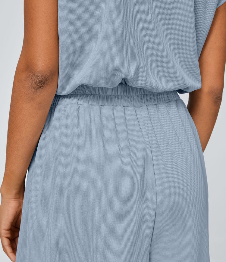 Jumpsuit mit V-Ausschnitt, kurzen Ärmeln, plissierten Seitentaschen und weitem Bein, fließendem Waffelmuster