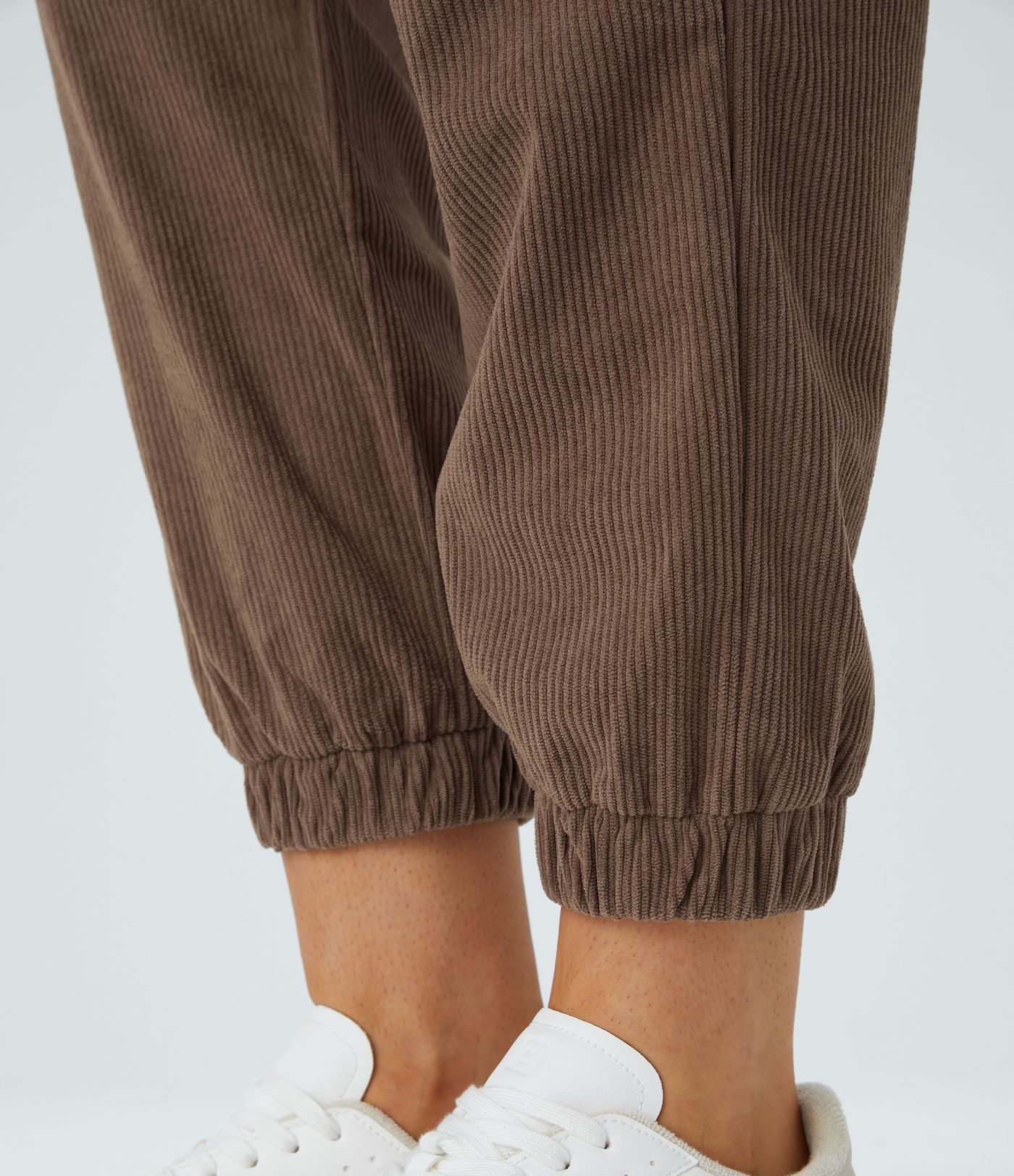 Casual corduroy jogger pants with mid waist, button, zipper, and multiple pockets