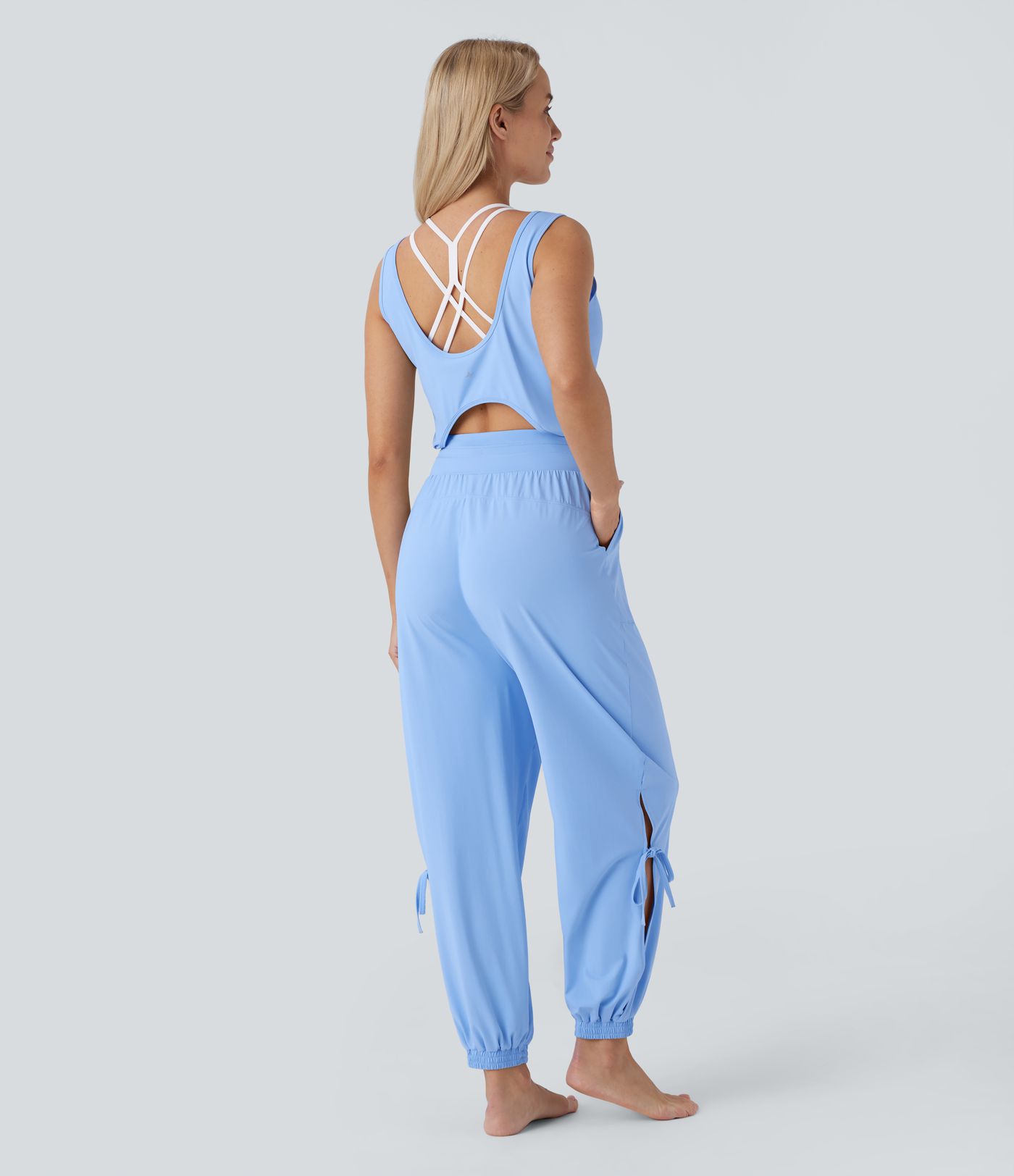 Jumpsuit de yoga sin mangas con espalda descubierta, cordón ajustable y bolsillos laterales de tacto fresco - UPF50+