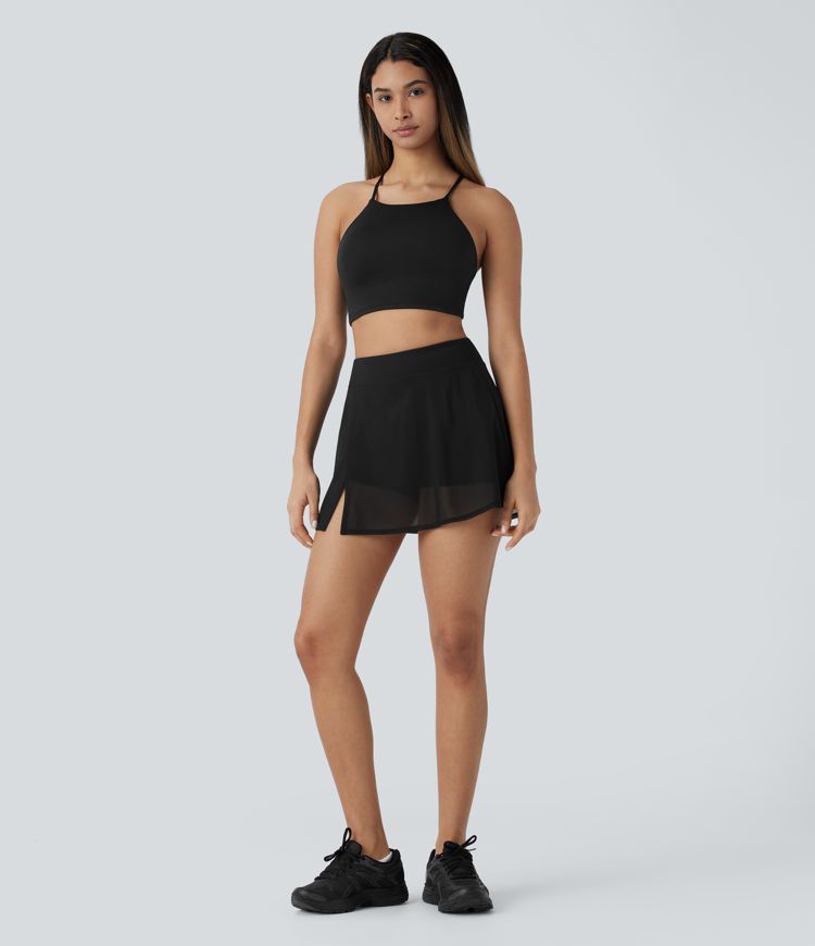 High-waisted yoga mini skirt with built-in shorts, side pockets, and contrasting mesh panels with slits