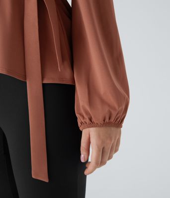Arbeitsbluse mit Schalkragen, seitlicher Masche und Rüschensaum Arbeitsbluse mit Schalkragen, seitlicher Masche und Rüschensaum