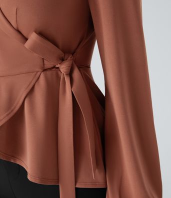 Arbeitsbluse mit Schalkragen, seitlicher Masche und Rüschensaum Arbeitsbluse mit Schalkragen, seitlicher Masche und Rüschensaum