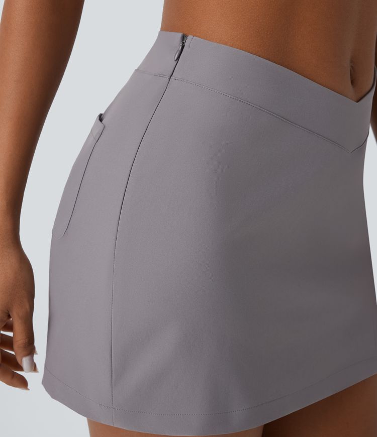 Mini-jupe décontractée en twill déperlante à taille basse avec ceinture en V, fermeture invisible et poche au dos
