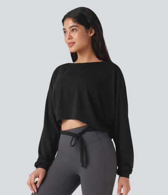 Top deportivo para correr de cuello redondo, manga larga, con aberturas y lazo en la espalda.