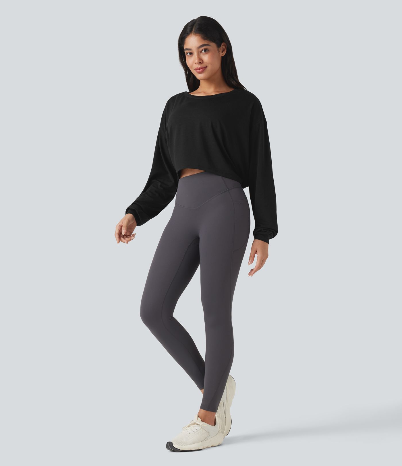 Top deportivo para correr de cuello redondo, manga larga, con aberturas y lazo en la espalda.