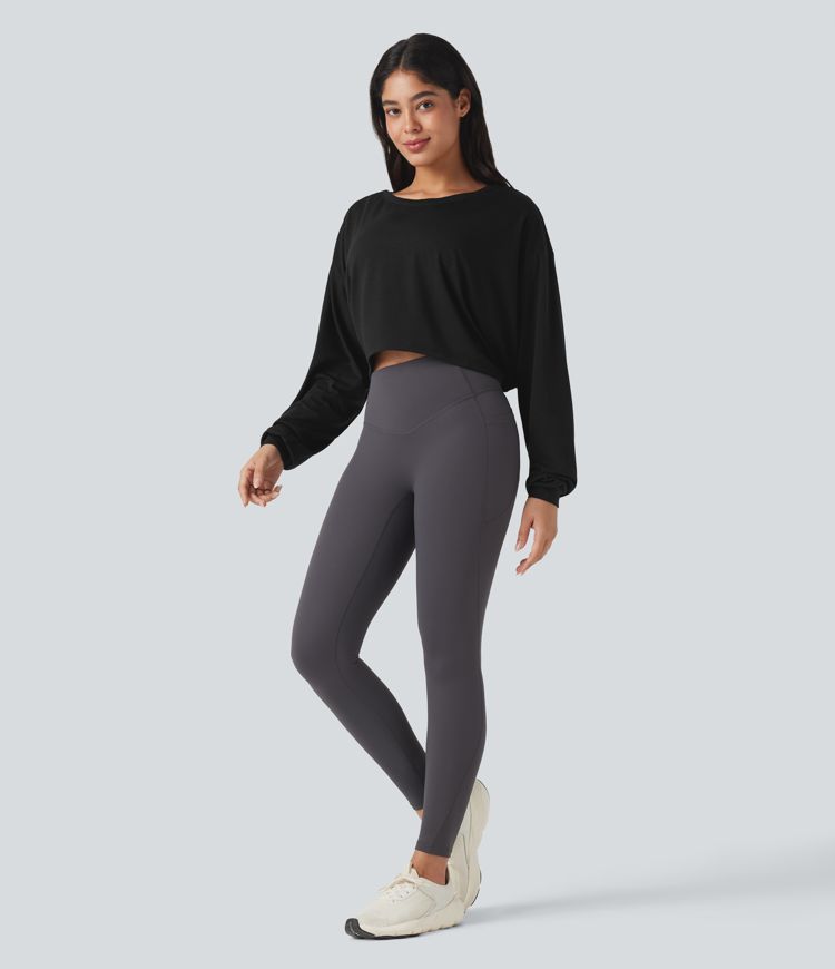 Top deportivo para correr de cuello redondo, manga larga, con aberturas y lazo en la espalda.