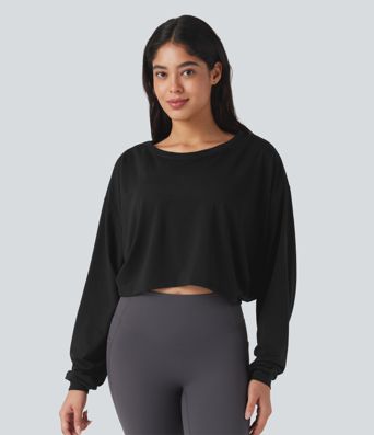 Top deportivo para correr de cuello redondo, manga larga, con aberturas y lazo en la espalda.