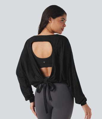 Top deportivo para correr de cuello redondo, manga larga, con aberturas y lazo en la espalda.