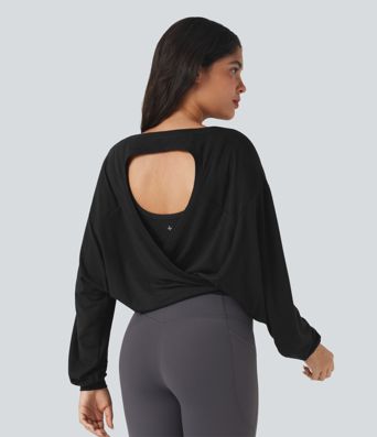 Top deportivo para correr de cuello redondo, manga larga, con aberturas y lazo en la espalda.