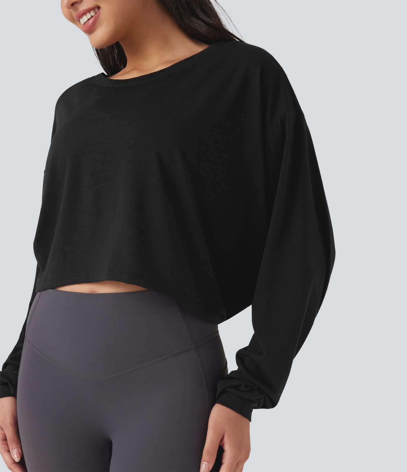 Top deportivo para correr de cuello redondo, manga larga, con aberturas y lazo en la espalda.