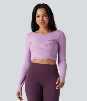 Trumpintas jogos sportinis topas su push-up efektu, formuotais spacer kaušeliais, apvalia iškirpte, ilgomis rankovėmis su nykščių angomis ir kryžminiu dizainu.