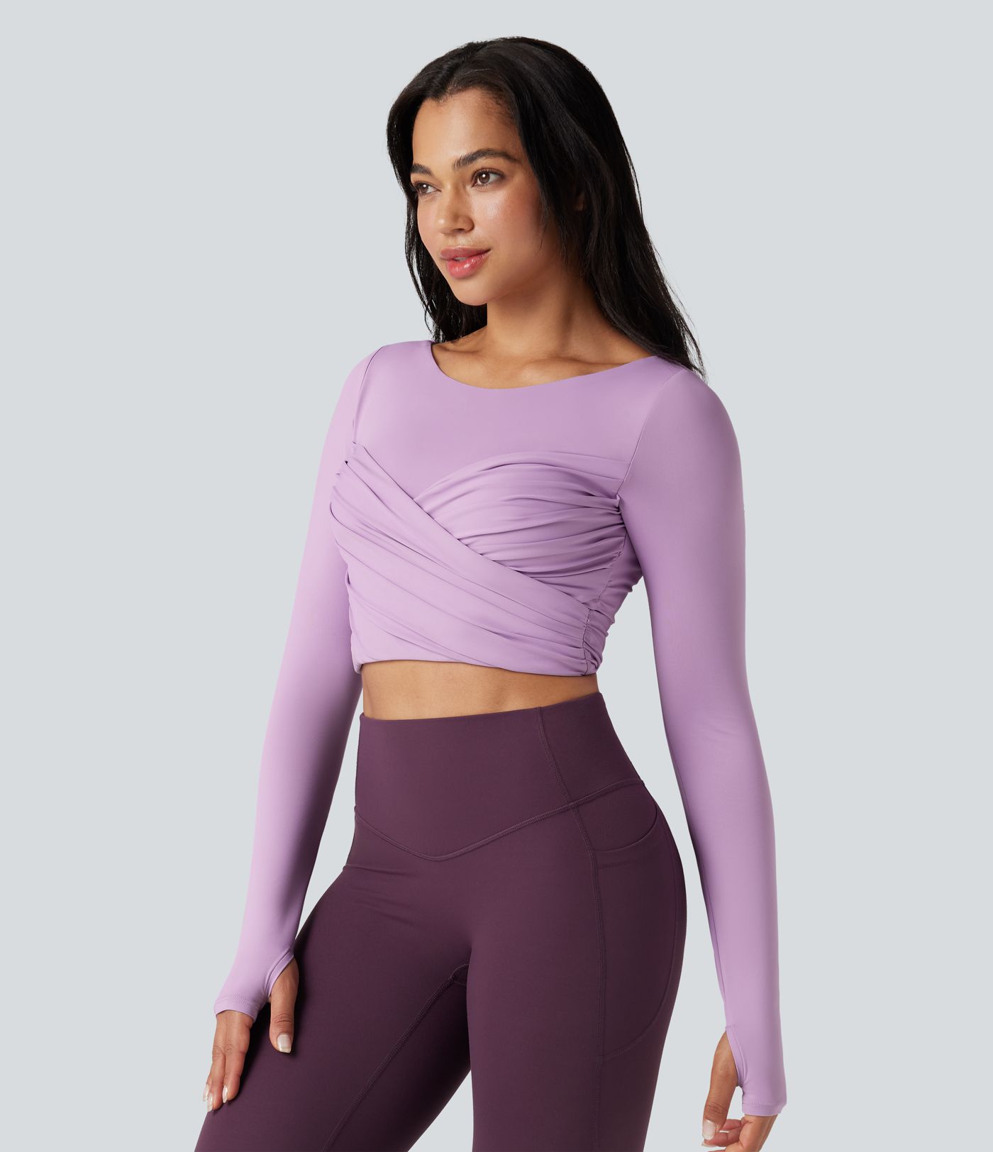 Trumpintas jogos sportinis topas su push-up efektu, formuotais spacer kaušeliais, apvalia iškirpte, ilgomis rankovėmis su nykščių angomis ir kryžminiu dizainu.