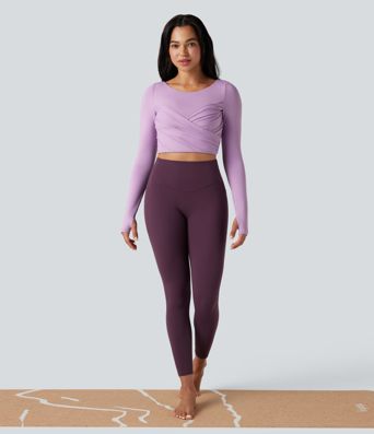 Trumpintas jogos sportinis topas su push-up efektu, formuotais spacer kaušeliais, apvalia iškirpte, ilgomis rankovėmis su nykščių angomis ir kryžminiu dizainu.