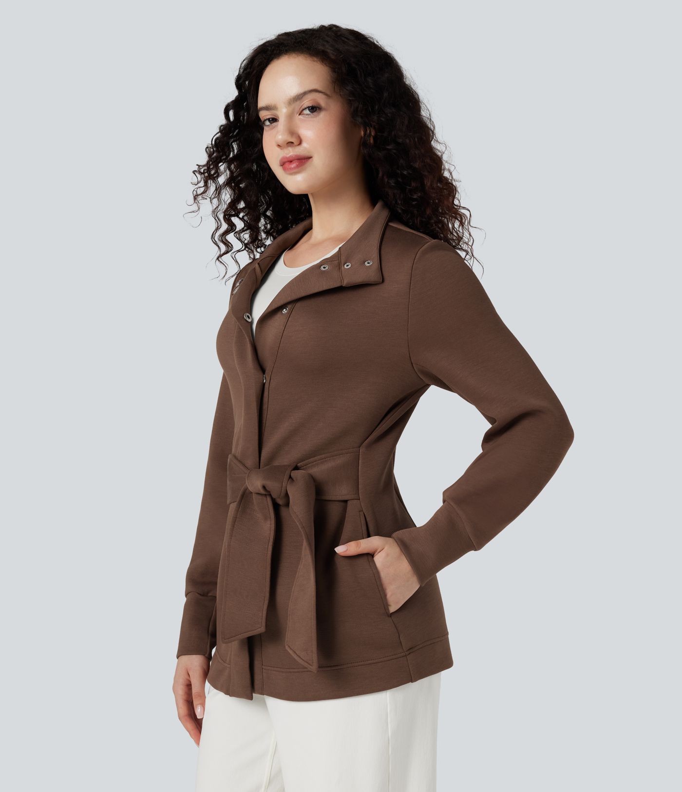 Högkragad långärmad arbetsrock med knytband och fickor.