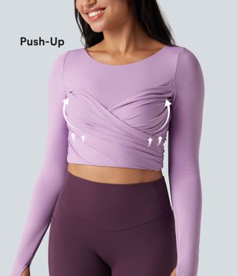 Trumpintas jogos sportinis topas su push-up efektu, formuotais spacer kaušeliais, apvalia iškirpte, ilgomis rankovėmis su nykščių angomis ir kryžminiu dizainu.