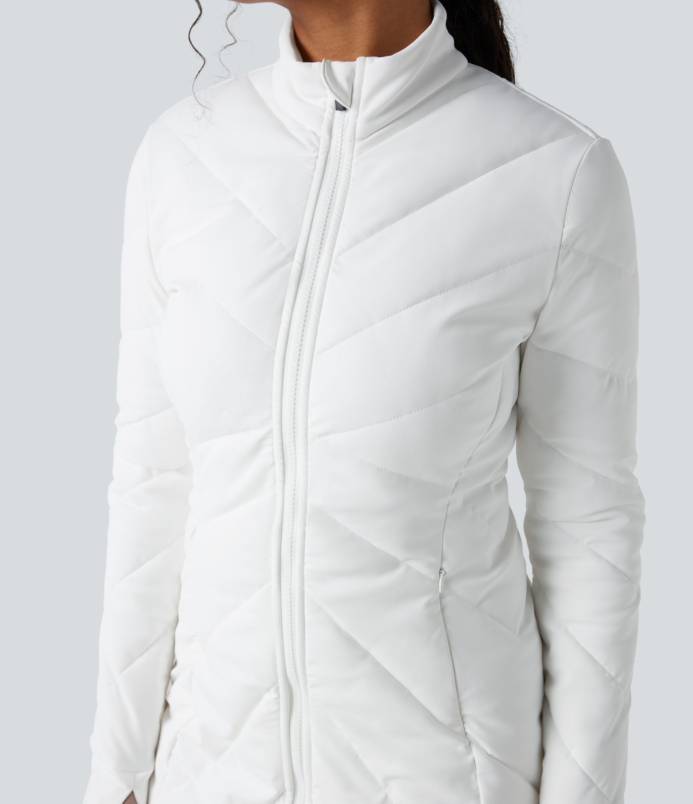 Chaqueta acolchada casual con cuello alto, doble cremallera, orificios para el pulgar y bolsillos.