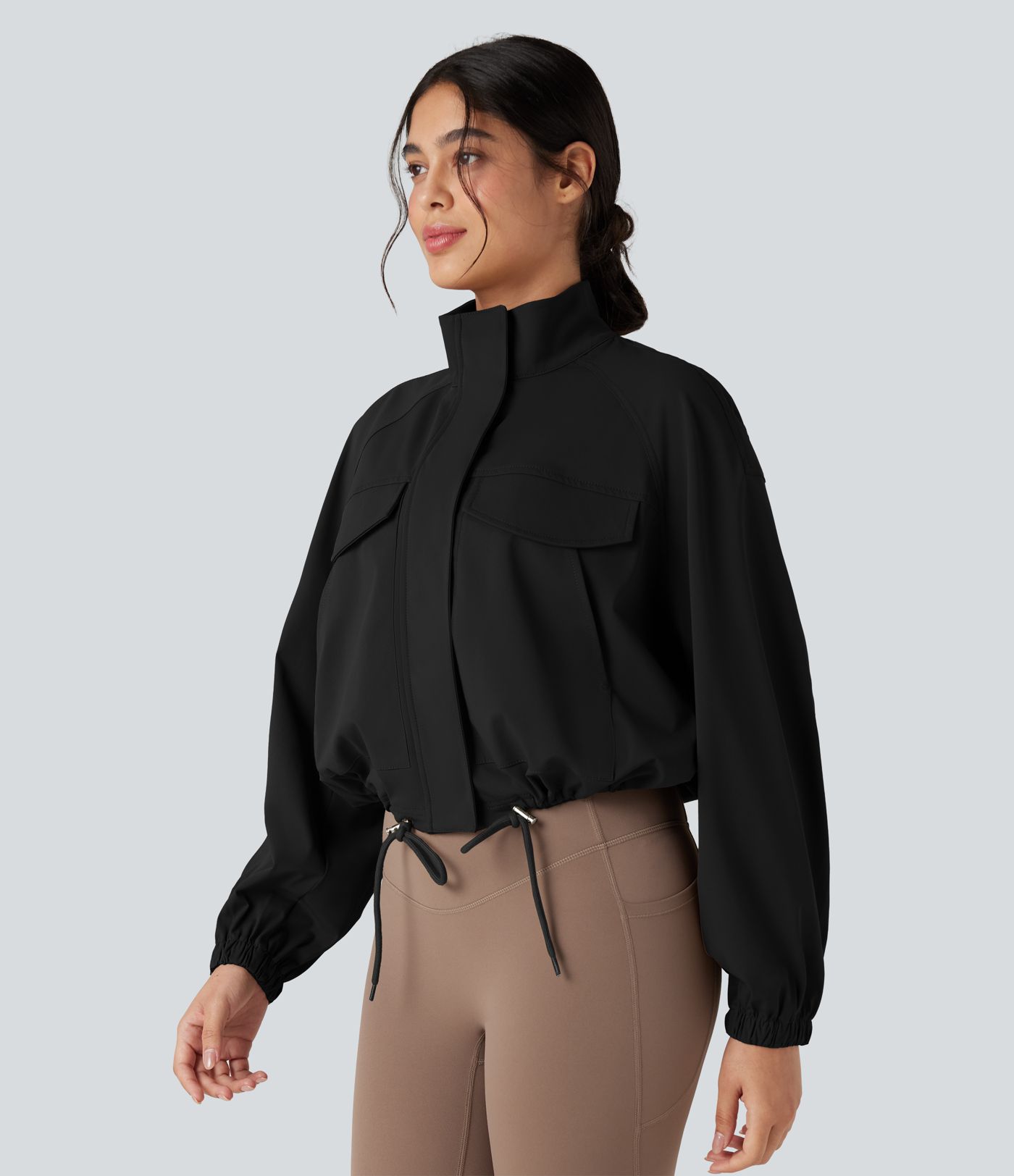 Chaqueta de entrenamiento con cuello alto, mangas largas, dobladillo con cordón y bolsillos.