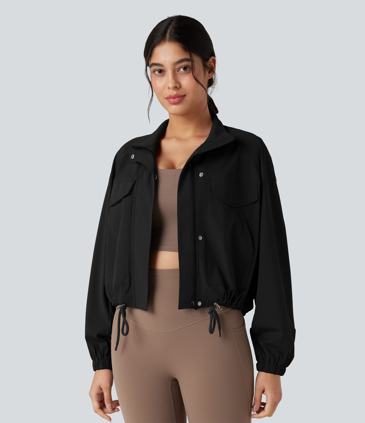 Chaqueta de entrenamiento con cuello alto, mangas largas, dobladillo con cordón y bolsillos.