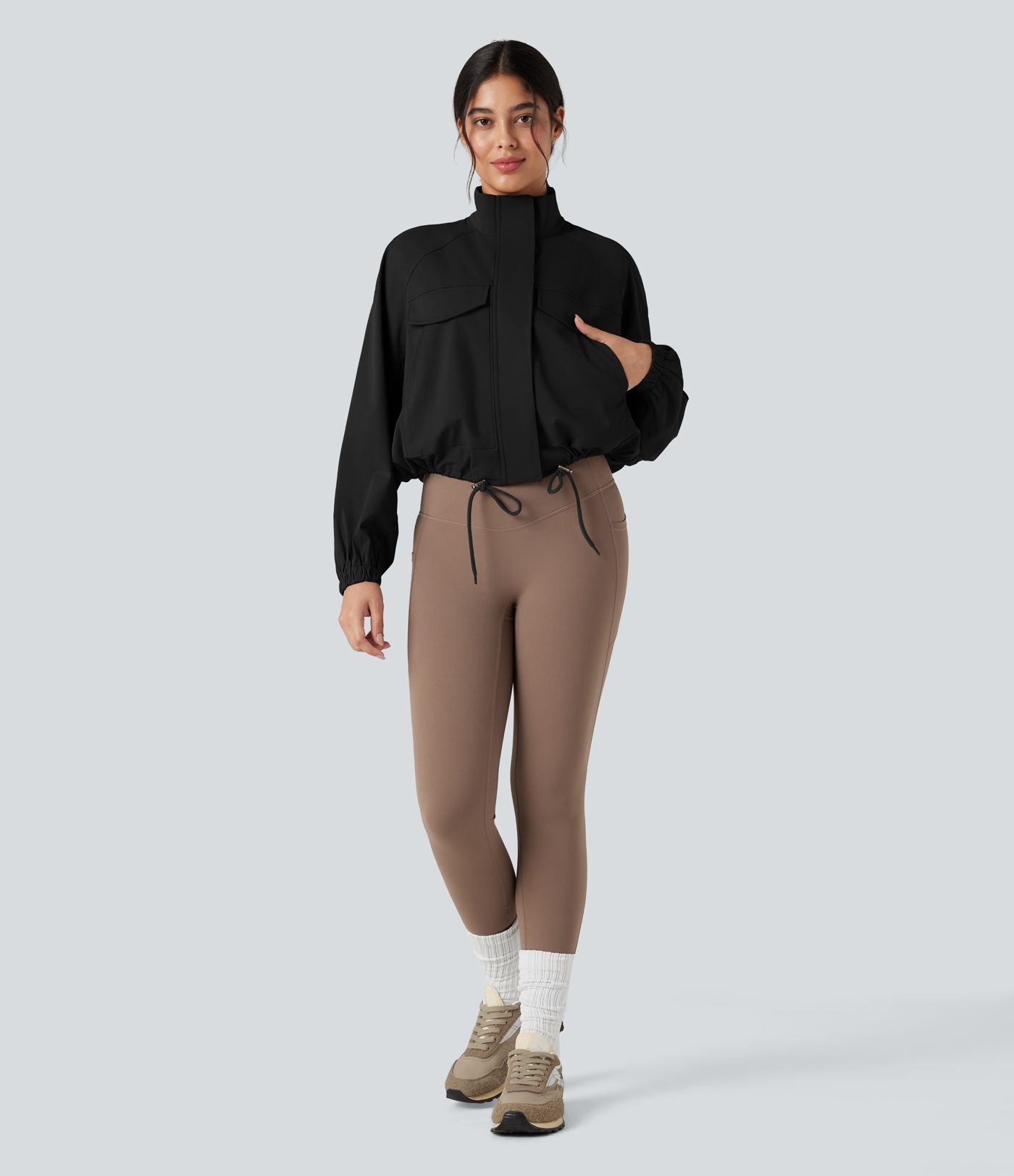 Chaqueta de entrenamiento con cuello alto, mangas largas, dobladillo con cordón y bolsillos.