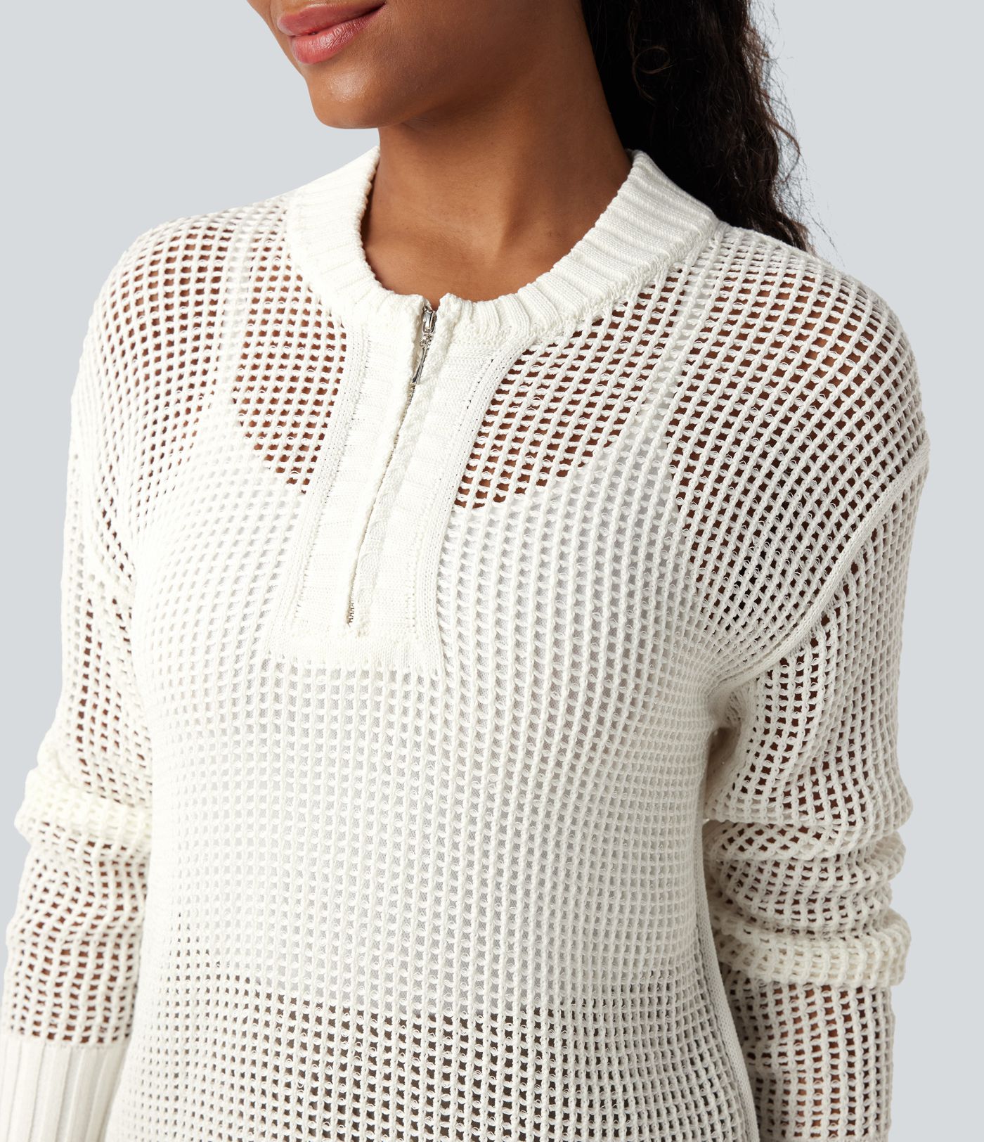 Pull décontracté à col rond avec demi-zip, manches longues et découpes.