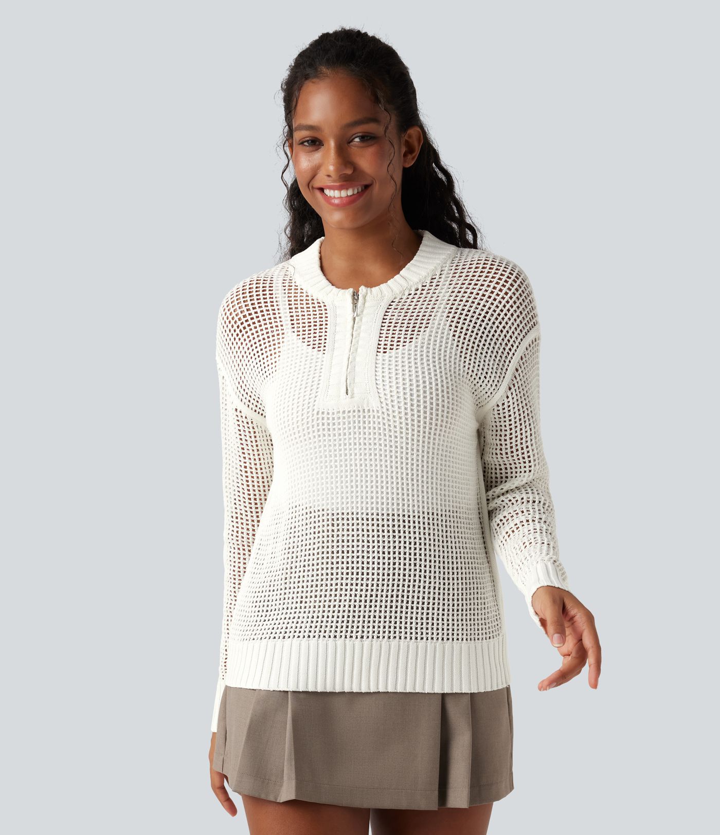 Pull décontracté à col rond avec demi-zip, manches longues et découpes.