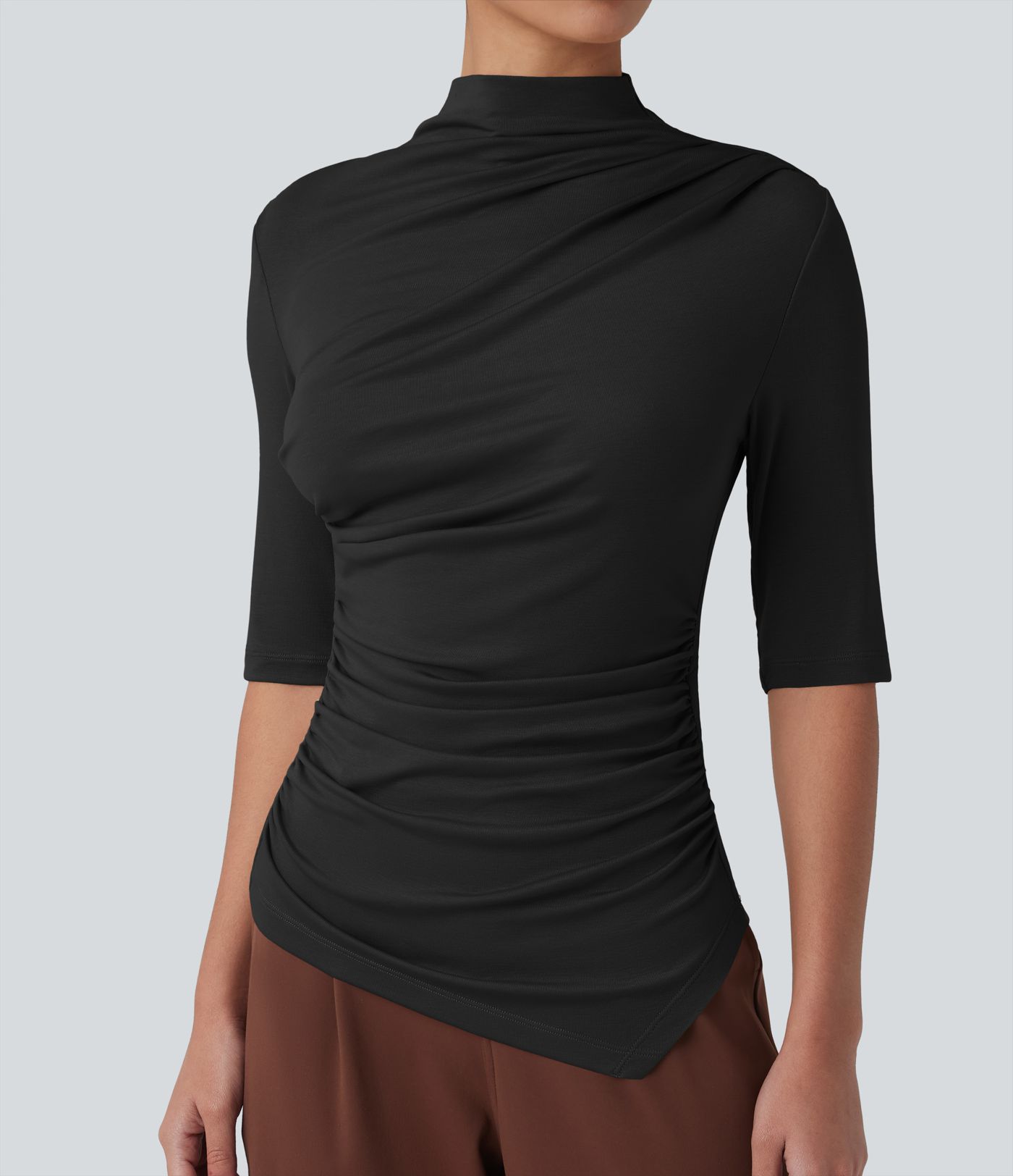 Ежедневен топ от рипсено плетиво с полувисока яка, половин ръкав, набор и асиметричен подгъв.