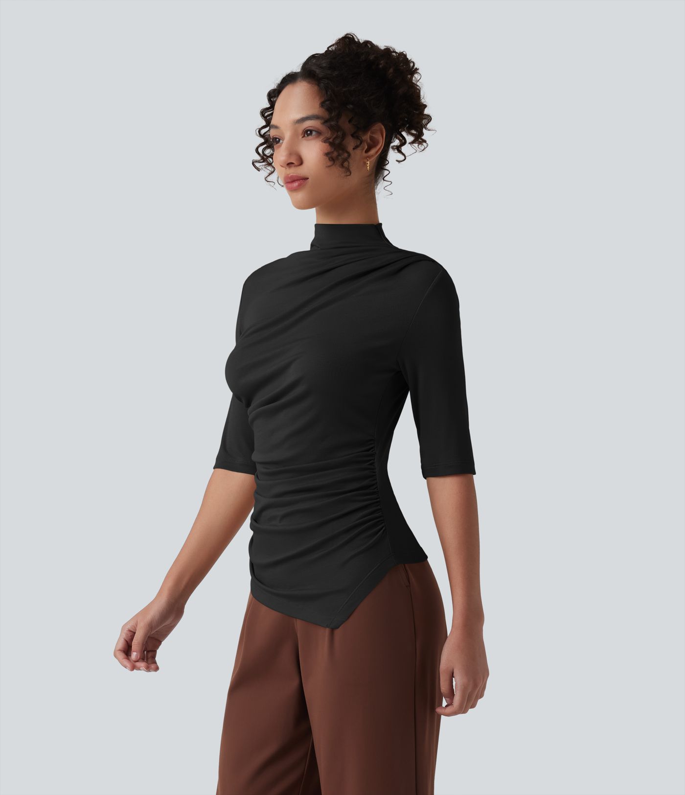 Ежедневен топ от рипсено плетиво с полувисока яка, половин ръкав, набор и асиметричен подгъв.