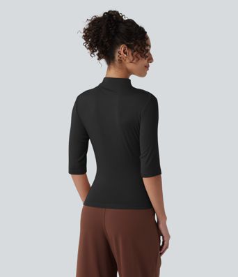 Ежедневен топ от рипсено плетиво с полувисока яка, половин ръкав, набор и асиметричен подгъв.