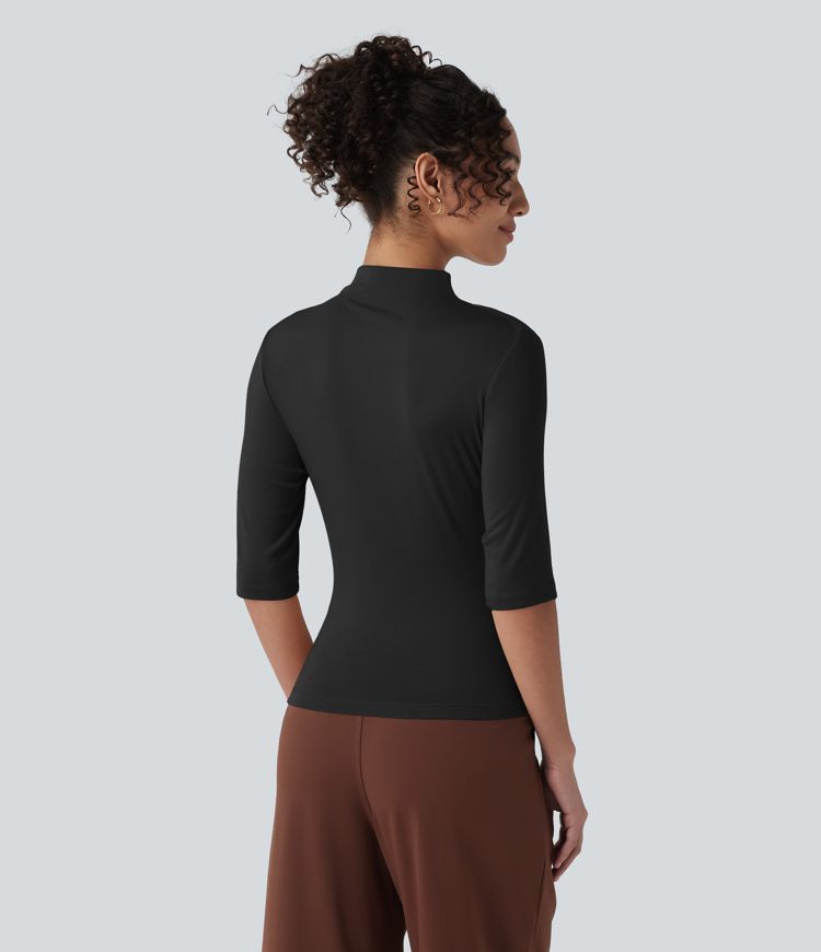 Ежедневен топ от рипсено плетиво с полувисока яка, половин ръкав, набор и асиметричен подгъв.