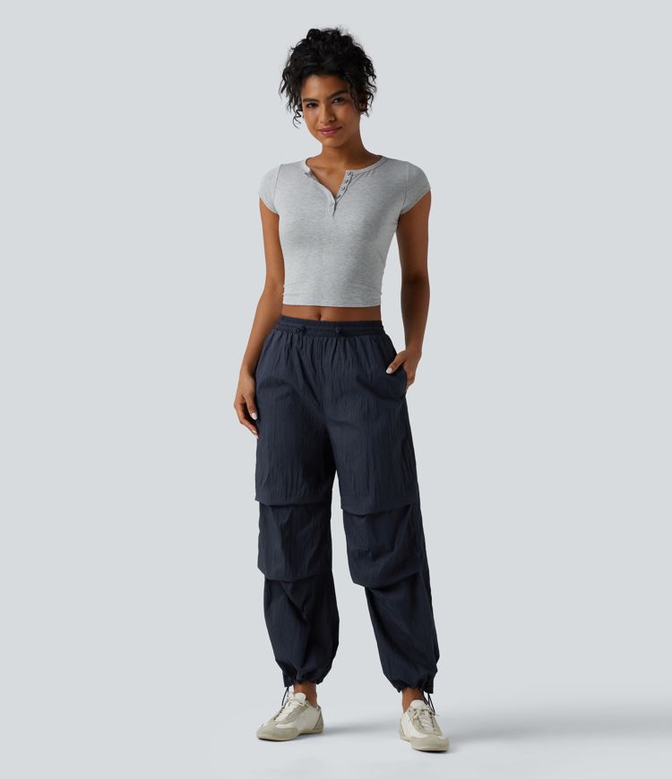 Pantaloni jogger casual tip parașută, ușor, durabili și hidrofugi, cu talie medie, croială dreaptă și buzunare.