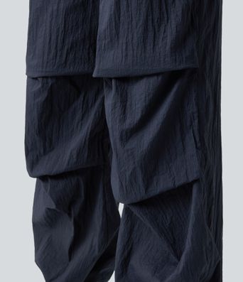 Pantaloni jogger casual tip parașută, ușor, durabili și hidrofugi, cu talie medie, croială dreaptă și buzunare.