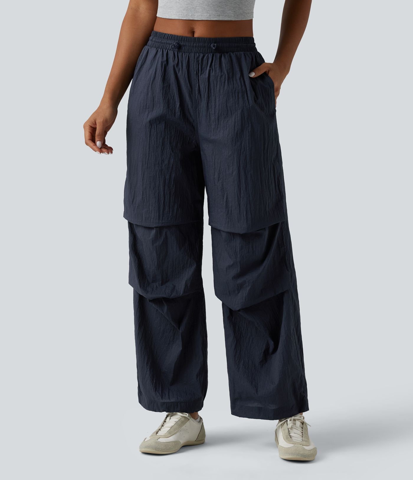 Pantaloni jogger casual tip parașută, ușor, durabili și hidrofugi, cu talie medie, croială dreaptă și buzunare.