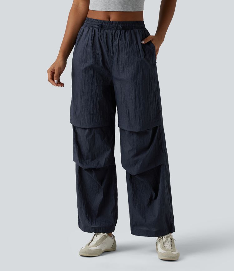 Pantaloni jogger casual tip parașută, ușor, durabili și hidrofugi, cu talie medie, croială dreaptă și buzunare.
