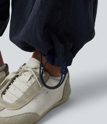 Pantaloni jogger casual tip parașută, ușor, durabili și hidrofugi, cu talie medie, croială dreaptă și buzunare.