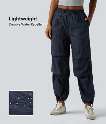 Pantaloni jogger casual tip parașută, ușor, durabili și hidrofugi, cu talie medie, croială dreaptă și buzunare.