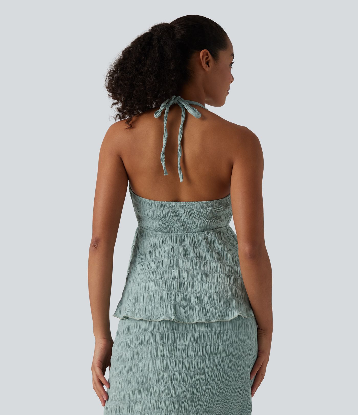 Halterový top se zavazováním vzadu a volánovým lemem.