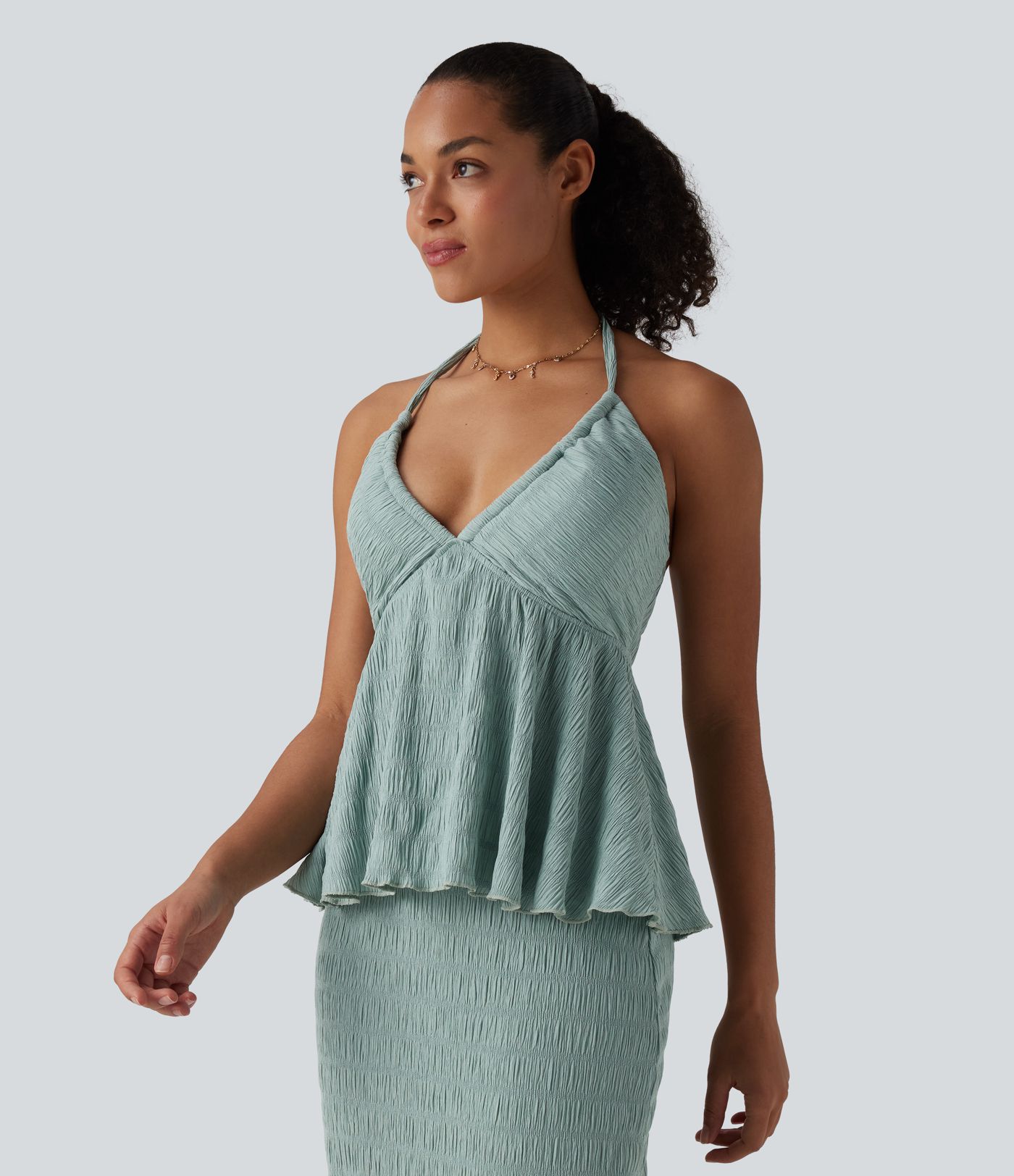 Halterový top se zavazováním vzadu a volánovým lemem.