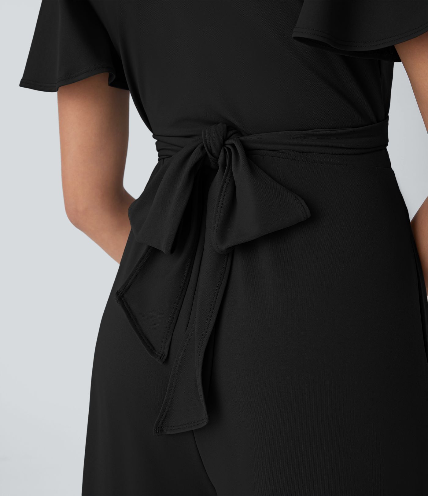 Combinaison fluide décontractée à col V, manches papillon, dos croisé avec lien et poches latérales, jambes amples