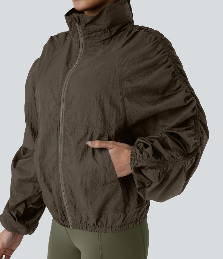 Veste de randonnée imperméable légère et compactable avec capuche rabattable, manches froncées et poches latérales