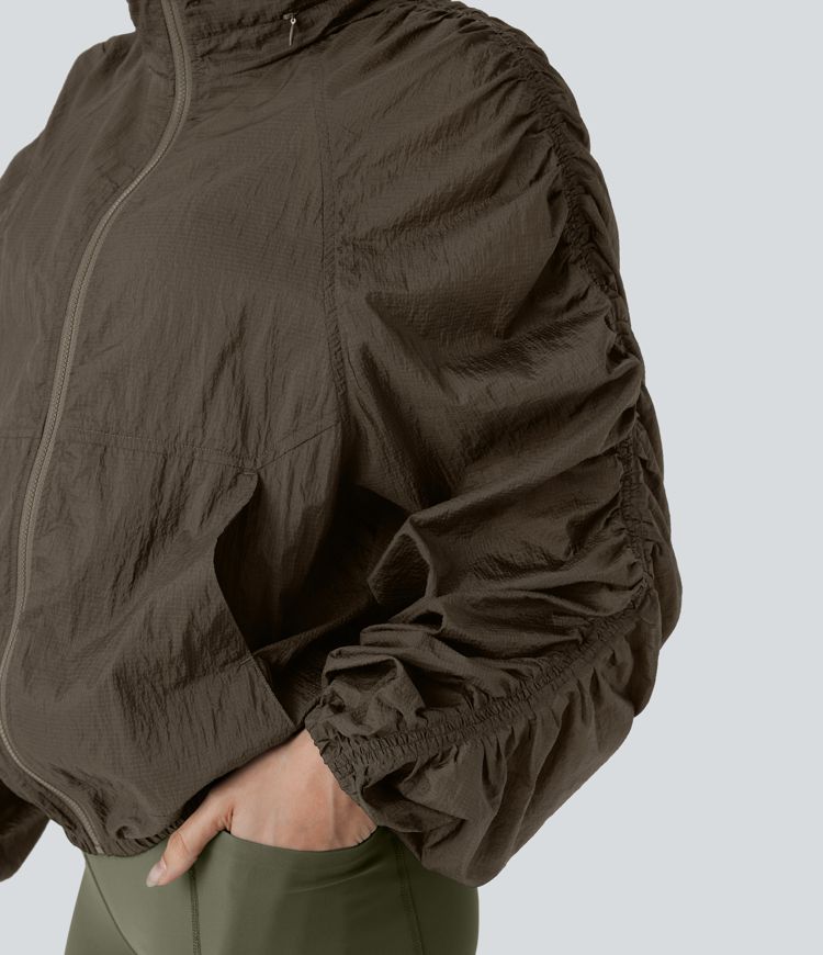 Veste de randonnée imperméable légère et compactable avec capuche rabattable, manches froncées et poches latérales