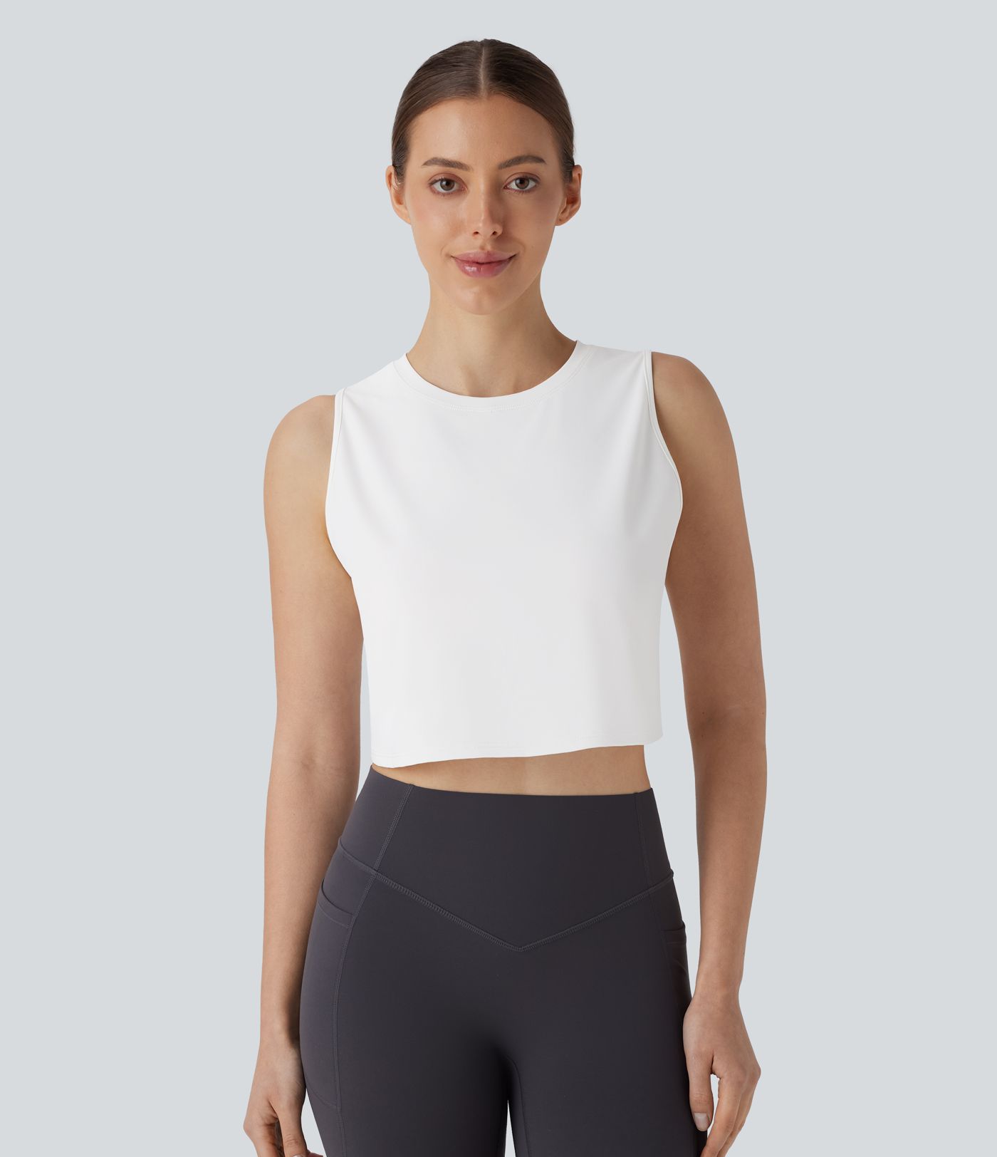 Einfarbiges, kurzes Yoga-Tanktop mit Cut-Outs und Crossover-Saum