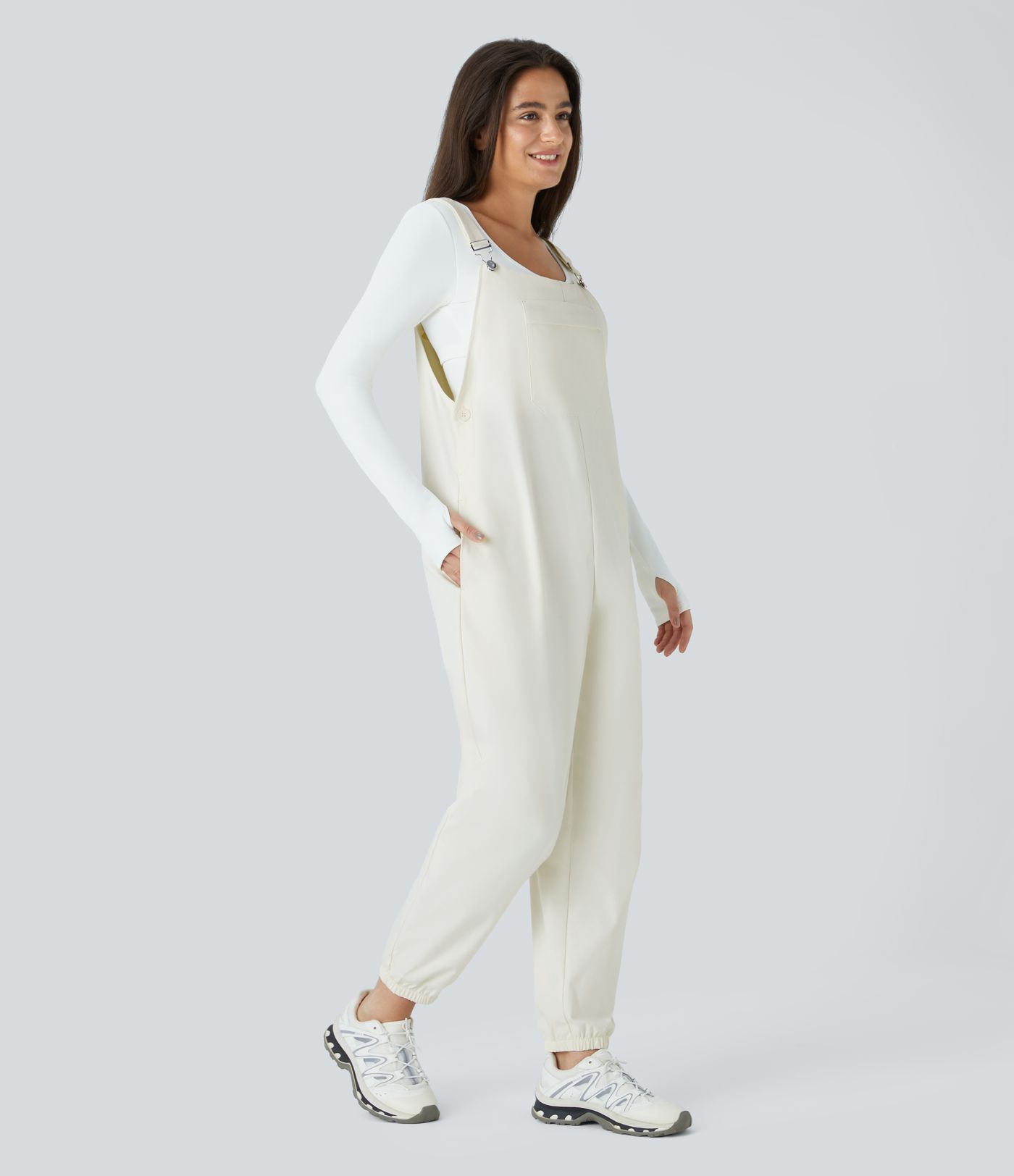 Adjustable strap with water-resistant and abrasion-resistant properties, multiple pockets, button closure, outdoor overall.