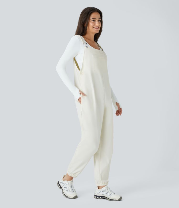 Adjustable strap with water-resistant and abrasion-resistant properties, multiple pockets, button closure, outdoor overall.