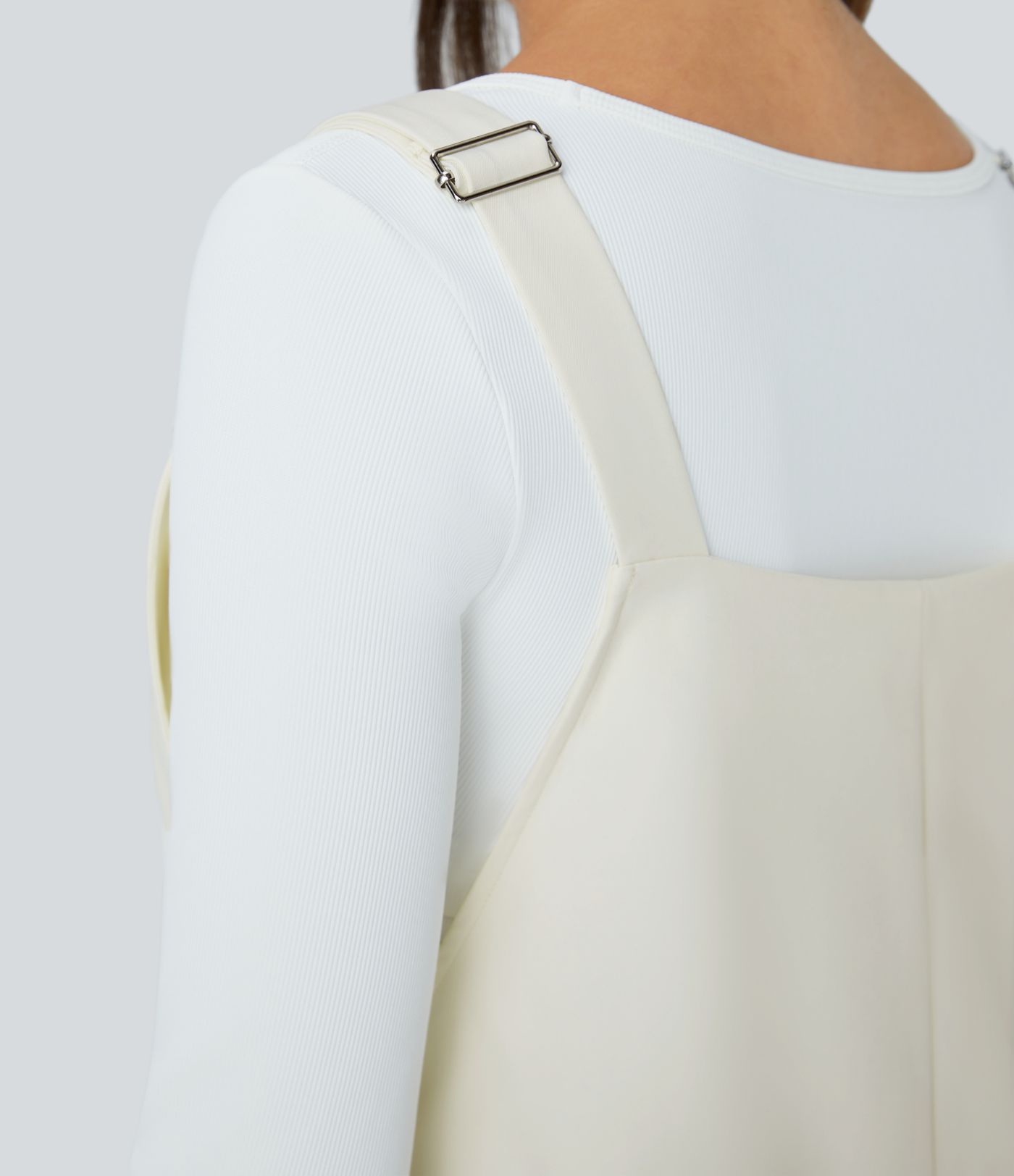 Adjustable strap with water-resistant and abrasion-resistant properties, multiple pockets, button closure, outdoor overall.