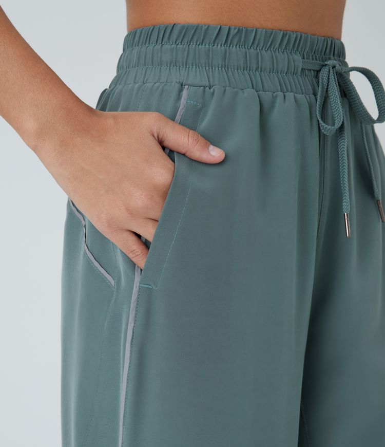 Pantalón correr tiro alto cordón ajustable bolsillo lateral dobladillo reflectante