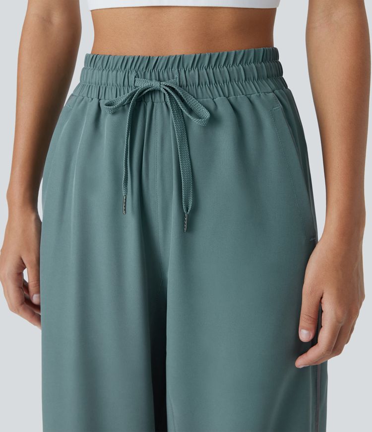 Pantalón correr tiro alto cordón ajustable bolsillo lateral dobladillo reflectante